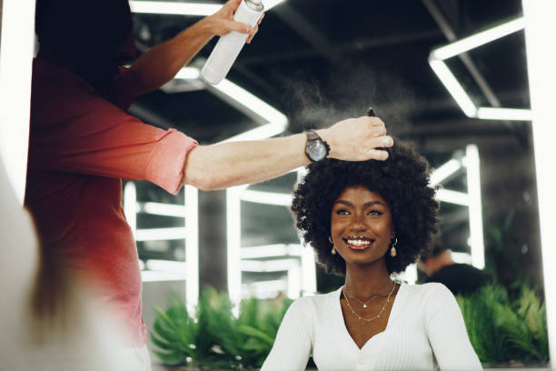 Young african woman customer getting a hairstyle at a beauty salon. Young african woman customer getting a hairstyle at a beauty salon, portrait natural hair stock pictures, royalty-free photos & images