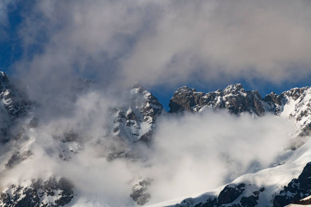istock Clouds over the snow covered mountains. High mountains peak, winter landscape. 1415169713