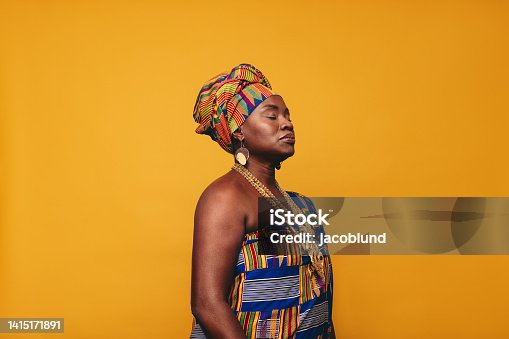 istock Mature woman wearing an African traditional atttire in a studio 1415171891