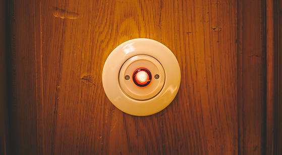 Photography of white porcelain light switch with red luminous push button in retro style in hotel in vienna.