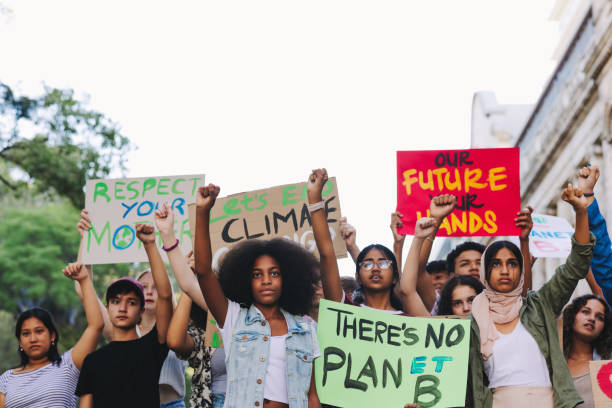 istock Diverse young people standing up against global warming 1415172102