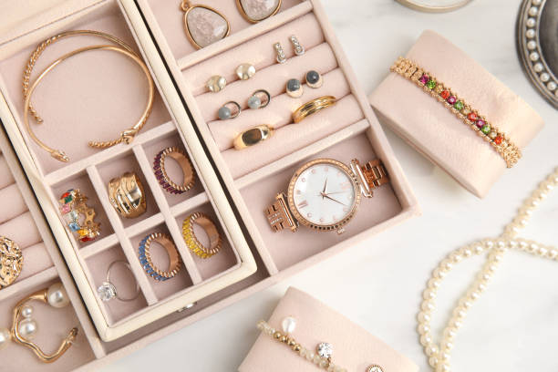 boîte à bijoux avec bijouterie dorée élégante sur table blanche, pose plate - bracelet jewelry personal accessory wristband photos et images de collection