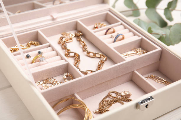 portagioie con elegante bigiotteria dorata su tavolo di legno bianco, primo piano - necklace gold bracelet jewelry foto e immagini stock