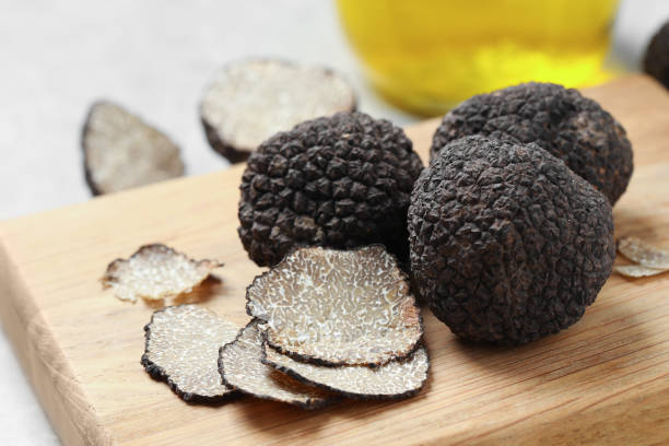 istock Black truffles with wooden board on table, closeup 1415173106