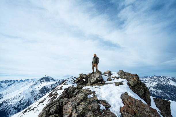 les hommes se tiennent au sommet de la montagne enneigée - caucasus mountains photos et images de collection