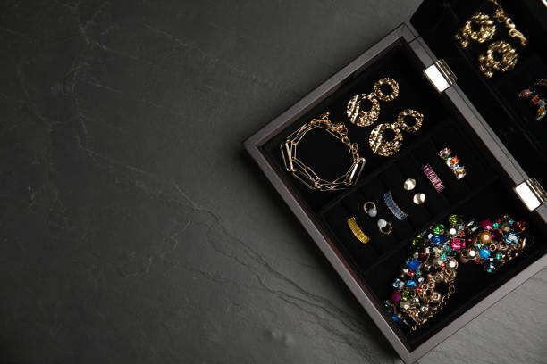 istock Jewelry box with stylish bijouterie on black table, top view. Space for text 1415174050
