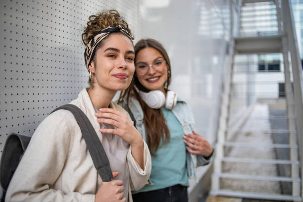 Portrait of female students walking around the university yard after class. Two female students after the lecture.