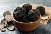 schwarze-tr%C3%BCffel-mit-holzschale-auf-grauem-tisch-nahaufnahme.jpg?b=1&s=170x170&k=20&c=9JoUeApMI-zFNuPciEEYoPoRtAxWshEXVH1mSK-xuuk=