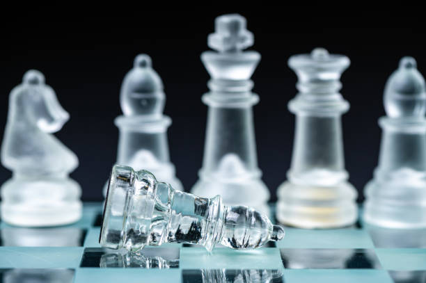 istock glass, transparent chess pieces on a checkerboard, selective focus, close-up, isolated on black 1415177560
