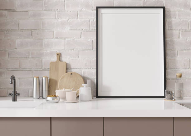 istock Empty vertical picture frame standing in modern kitchen. Mock up interior in minimalist, contemporary style. Free, copy space for your picture, poster. Close up view. 3D rendering. 1415177590