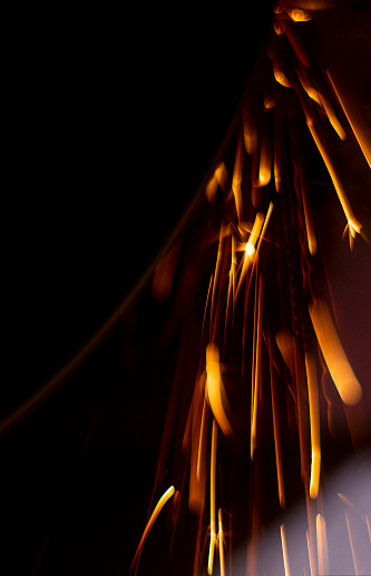 abstract image of sparks from a circular saw, photographed in close-up macro mode. Front and back background blurred with bokeh effect