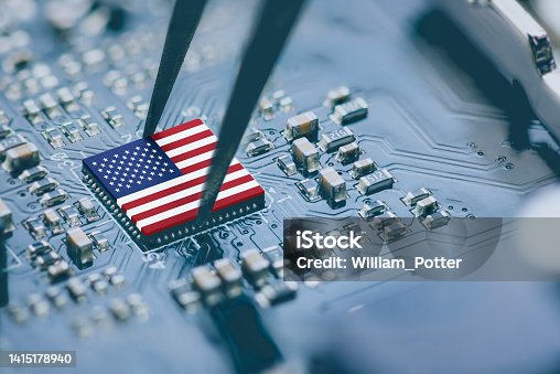 istock Flag of USA on a processor, CPU Central processing Unit or GPU microchip on a motherboard. Congress passes the CHIPS Act of 2022 to strengthen domestic semiconductor manufacturing, research and design. 1415178940