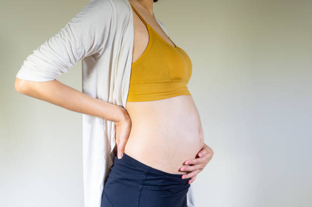 Pregnant woman, Backache during pregnancy. Pregnant woman suffering from lower back pain. Pregnant woman, Backache during pregnancy. Pregnant woman suffering from lower back pain. First Symptoms of Pregnancy stock pictures, royalty-free photos & images