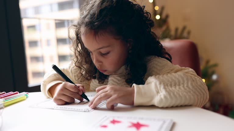 Little girl drawing Christmas cards