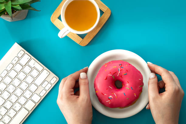 istock Donut, tea and keyboard on a blue background, flat lay. 1415185852
