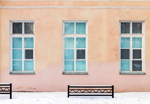 Three windows in pink wall on a winter day, classic architecture background texture