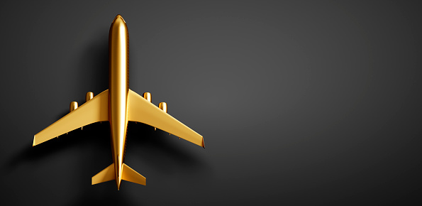 Golden airplane on dark background with copy space