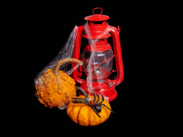 Composition, halloween banner. on a black background, a red kerosene lamp and orange pumpkins with cobwebs. Isolated object, cut object, copy paste