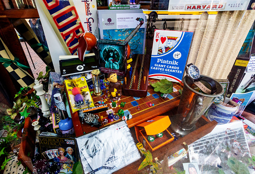 Cambridge, Massachusetts, USA - August 14, 2022: View through a Harvard Square retail store display window of an assortment of games, amusements and trinkets.