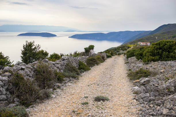 Old road near Predoscica (Cres, Croatia) on a cloudy day in springtime