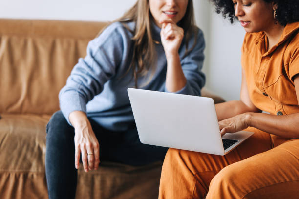 istock Two young businesswomen using a laptop together in an office 1415189390
