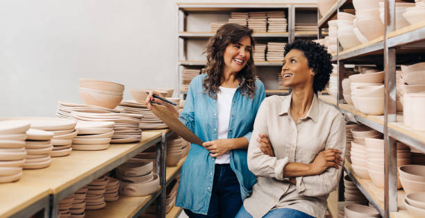 istock Two ceramic shop owners smiling at each other in their store 1415189502