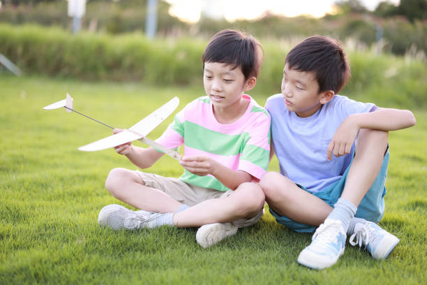 istock Boy playing with toy planes in park 1415190533