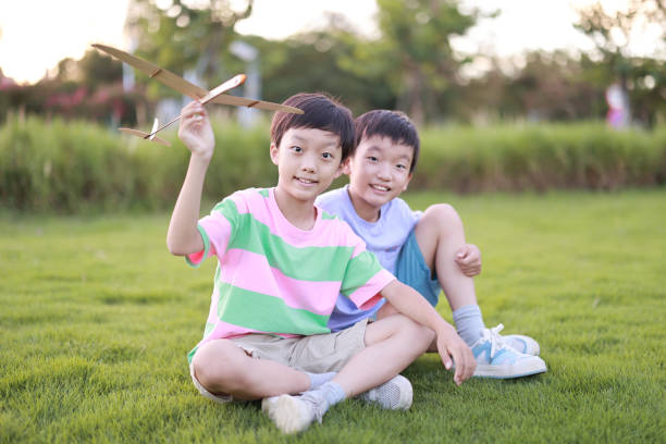istock Boy playing with toy planes in park 1415190535