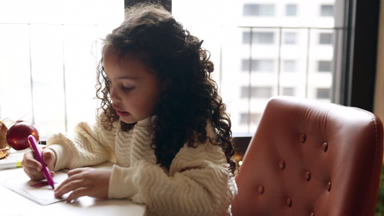 Little girl drawing Christmas cards