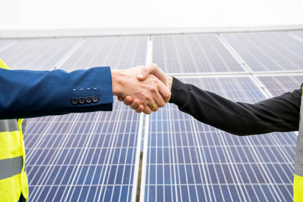 istock two young handsome men in overalls and caste shake hands after installing power panels. 1415192780