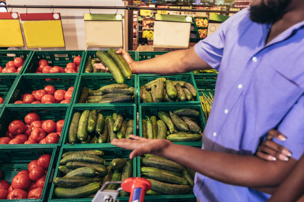 istock Man is choosing vegetables while doing shopping at the supermarket 1415192888