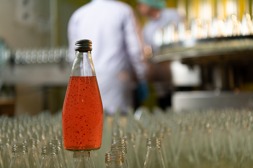 Product quality control officer in fruit juice production line Carry out an inspection of bottles used to contain fruit juices. To ensure quality can be sent to the production line