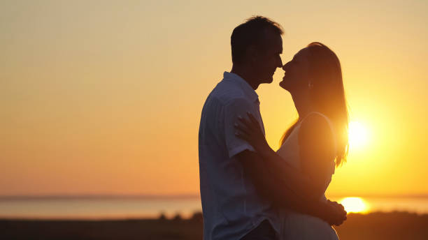 istock Husband expresses true love to gorgeous lover at back sunset 1415194349
