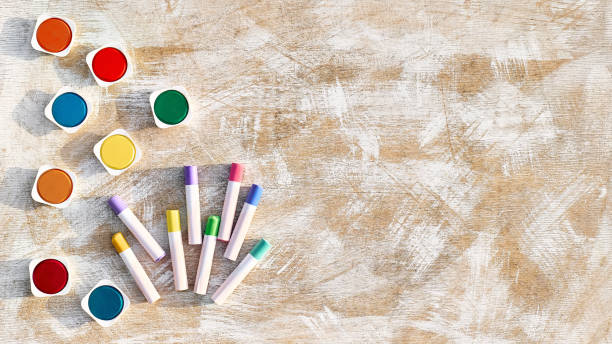 istock Chalks and watercolors on light wooden background. Creative template, back to school concept. Tools for creative leisure. Painting hobby background. 1415194561
