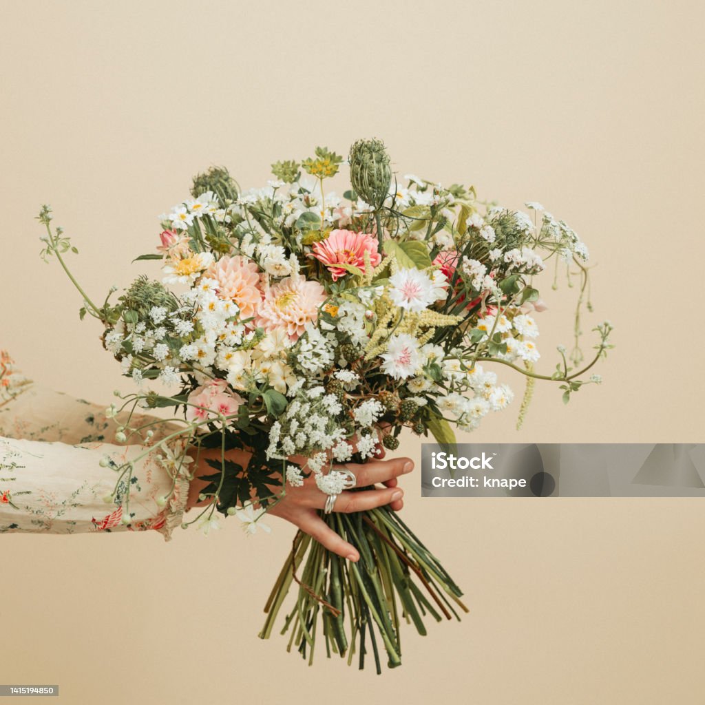 Woman holding bouquet of flowers studio shot pastel Flower Stock Photo