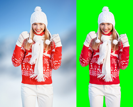 Young woman wear red winter pullover, white hat, smiling, hands raised, blurred snow country background, isolated selection on green background included