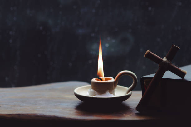 The rain falling on the window, the flowing raindrops, the soothing sound of rain, the cross, the candle, and the Bible symbolizing the suffering, death and resurrection of Jesus Christ