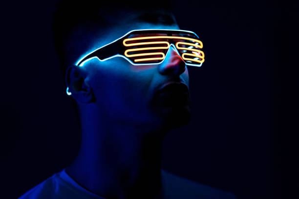 The man in futuristic glasses standing in the dark room stock photo