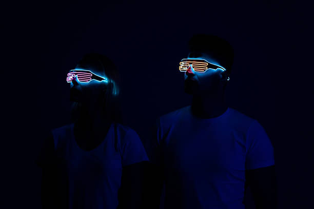 мужчина и женщина в виртуальных очках стоят в темной комнате - hologram led futuristic women стоковые фото и изображения