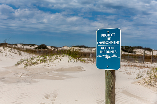 Sign instructing visitors to keep off the sand dunes in order to protect this fragile environment from erosion.