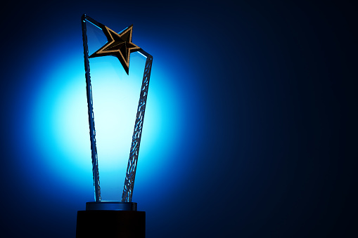 light on the star shapecrystal trophy against blue background