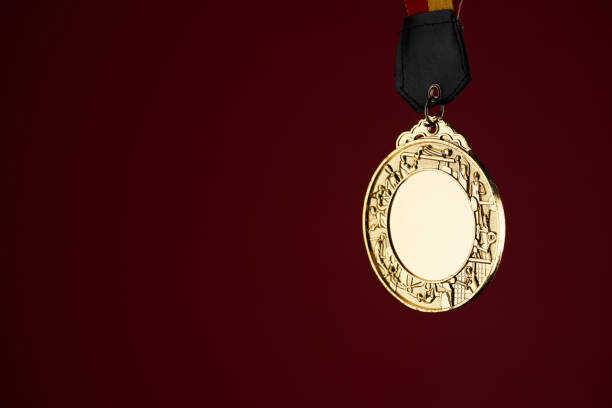 istock gold color medal against red background with copy space 1415203648