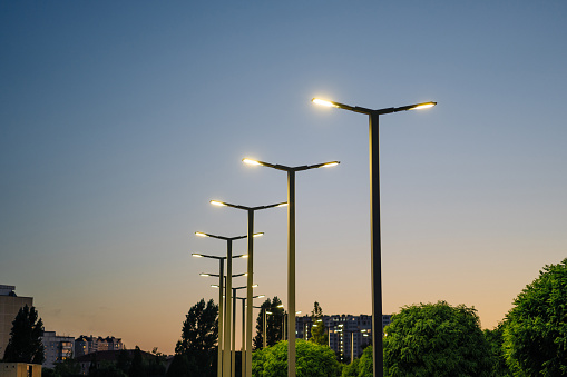 A modern street LED lighting pole. Urban electro-energy technologies. A row of street lights against the night sky.