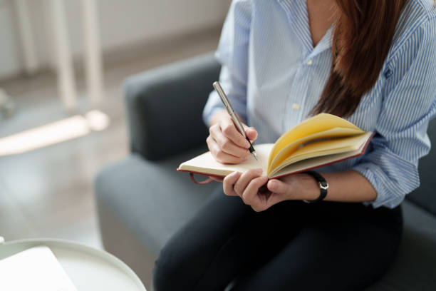 istock Cropped photo of woman writing making list taking notes in notepad working or learning on laptop indoors- educational course or training, seminar, education online concept 1415209303