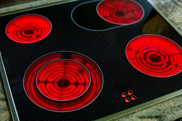 close-up de um fogão de indução vermelho redondo brilhante - stove ceramic burner electricity - fotografias e filmes do acervo