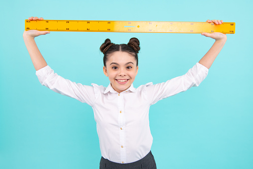 Teenager school girl study math or geometry lesson, measure the size. Mathematics ruler for measuring. Happy positive and smiling schoolgirl