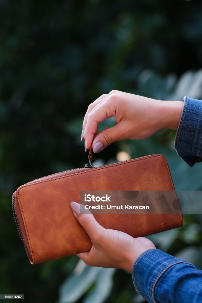 leather wallet woman opens her wallet. brown wallet Wallet Stock Photo