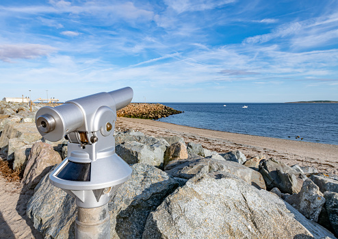 Blue tourist monocular with a beautiful mediterranean landscape in the background on a sunny summer day. Copy space for text.  Selective focus  \