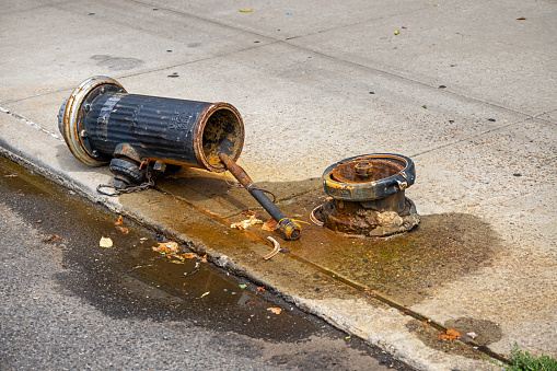 Broken fire hydrant lying on the sidewalk in Long Island City, New York