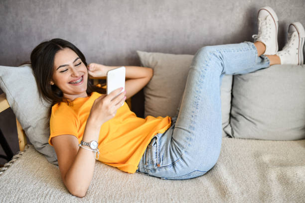 istock Smiling Female Looking At Received Text Message On Smartphone 1415217522